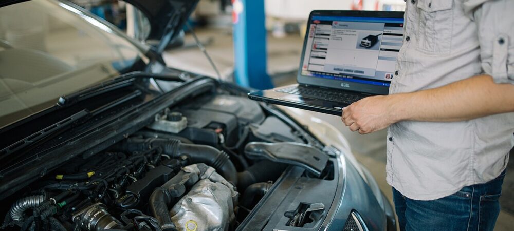 Mecanic care verifică motorul unei mașini în atelierul de service